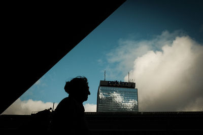 Rear view of silhouette man standing against sky