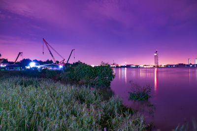 Illuminated commercial dock against sky at dusk