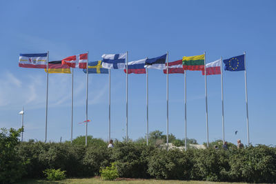 Low angle view of flags against blue sky