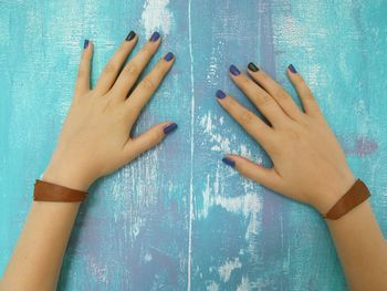 Cropped image of woman hands on weathered wall