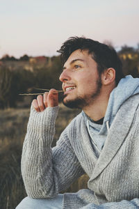 Portrait of young man holding sunglasses in winter