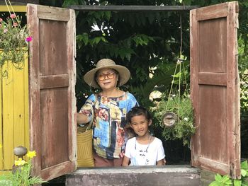 Portrait of smiling girl standing against wall