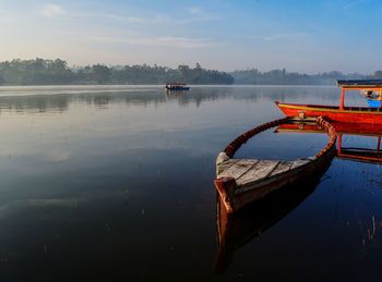 Boat moored in lake against sky