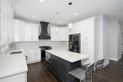 Remodeled kitchen has white cabinets installed and modern appliances