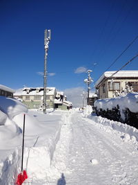 Snow covered buildings against blue sky