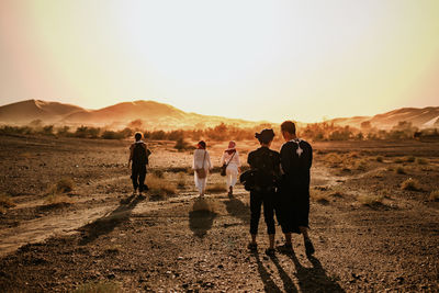 People standing on field against mountain