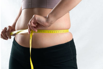Midsection of woman standing against wall