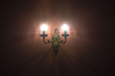 Close-up of illuminated lamp against black background