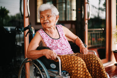 Full length portrait of woman sitting outdoors