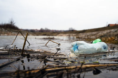 Garbage in calm river against sky