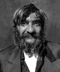 Close-up portrait of bearded man against wall