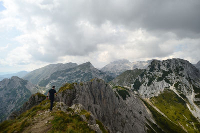 Rear view of man walking on mountain peak