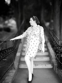 Woman standing on staircase in city