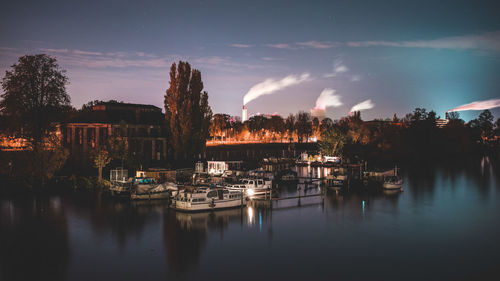 Boats moored in harbor at night