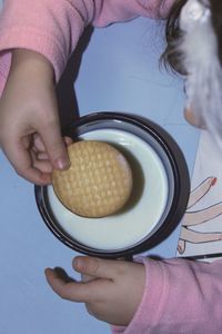 Cropped image of girl holding biscuit