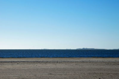 Scenic view of beach against clear blue sky