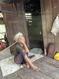 Full length of woman sitting on wood