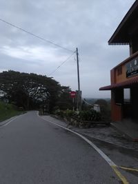 Road leading towards city against sky