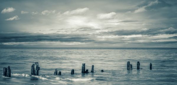 Scenic view of sea against cloudy sky