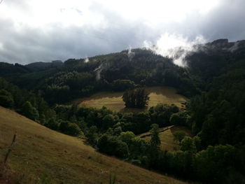 Scenic view of fields against cloudy sky