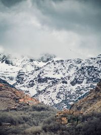 Scenic view of snowcapped mountain against cloudy sky