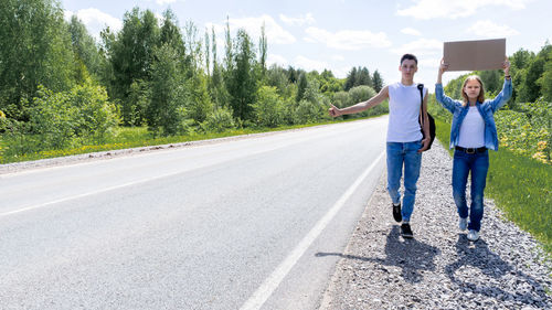 Rear view of couple walking on road