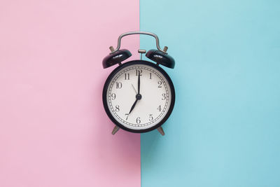 Directly above shot of alarm clock on colored background