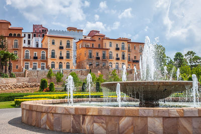 Fountain in park against sky