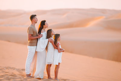 Side view of family looking away while standing at desert