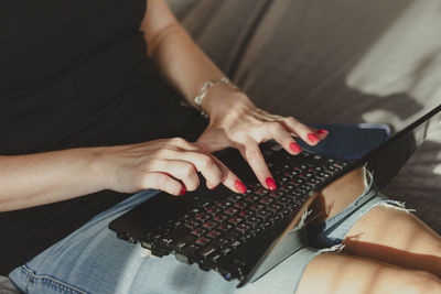 Young millennial woman typing on laptop. working at home, freelancer job concept, dynamic workplace.