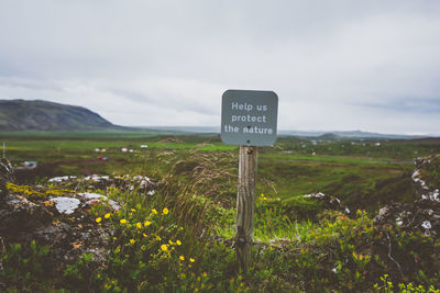 Information sign on landscape against sky