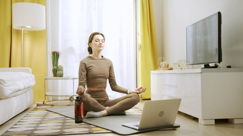 Full length of woman sitting on table