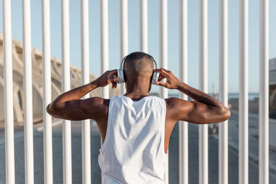 Rear view of man standing against railing