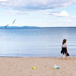 Rear view full length of girl walking on shore at beach