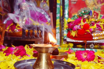 Close-up of illuminated diya during traditional ceremony