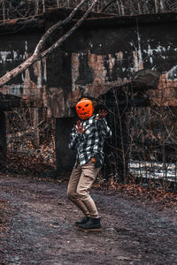 Full length of boy standing by tree