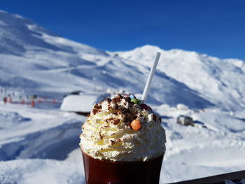 Ice cream against snowcapped mountains during winter