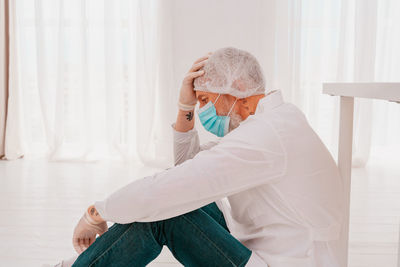 Side view of worried doctor sitting in hospital