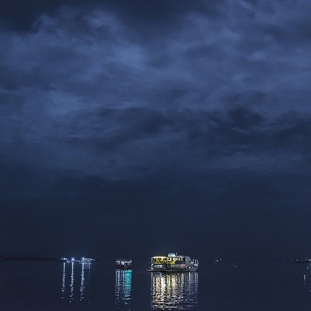 sky, water, cloud - sky, sea, built structure, silhouette, waterfront, architecture, illuminated, dusk, cloudy, nature, night, city, tranquility, river, scenics, cloud, beauty in nature, outdoors