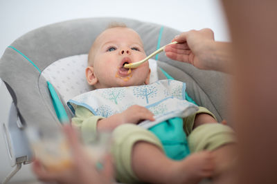 Midsection of baby boy lying on bed at home