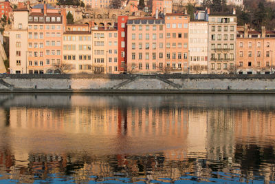 The quays of saône in lyon with its old buildings reflecting in the water with the morning light