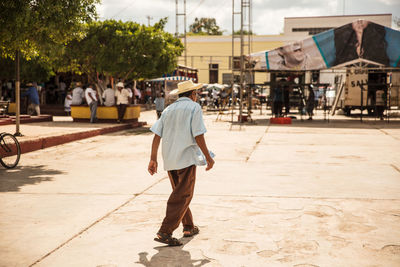 Rear view of man walking on street in city