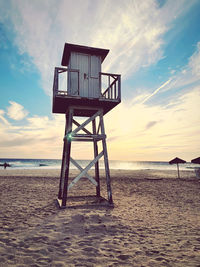Lifeguard hut on beach against sky