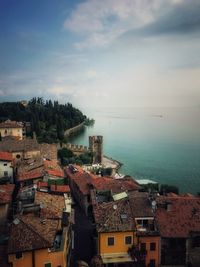 High angle view of townscape by sea against sky