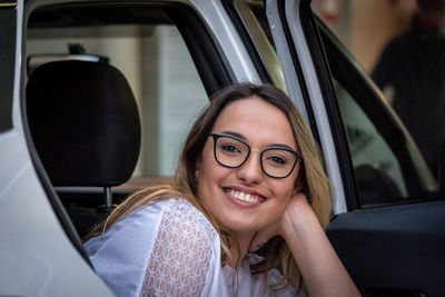 Portrait of happy young woman in car