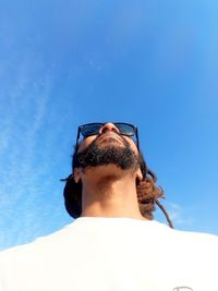 Low angle view of man against blue sky