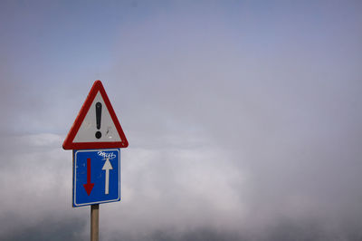 Road sign against sky