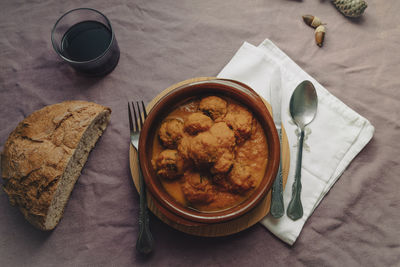 Meatball stew with tomato sauce in earthenware casserole dish.