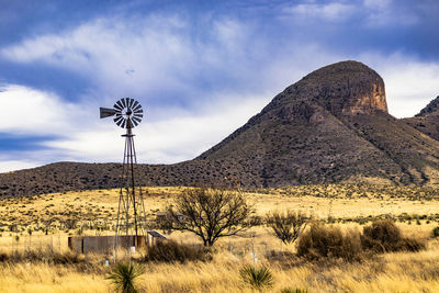 Windmill on field against sky