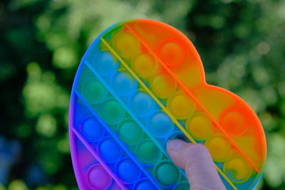 Close-up of hand holding multi colored balloons